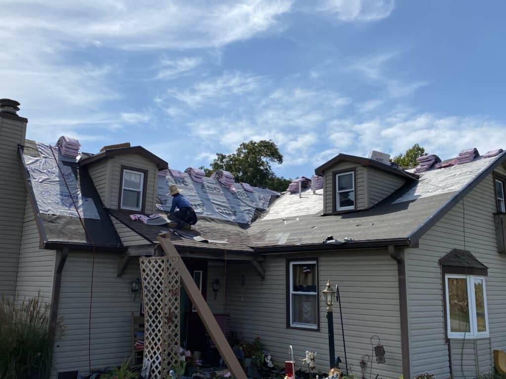 Roofing contractors install a new roof after Indiana hail damage. 