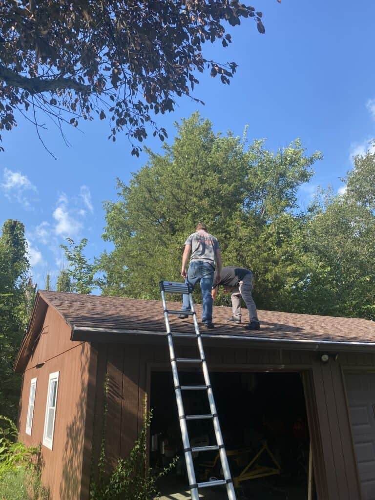 Roofing contractors inspect a roof for storm damage